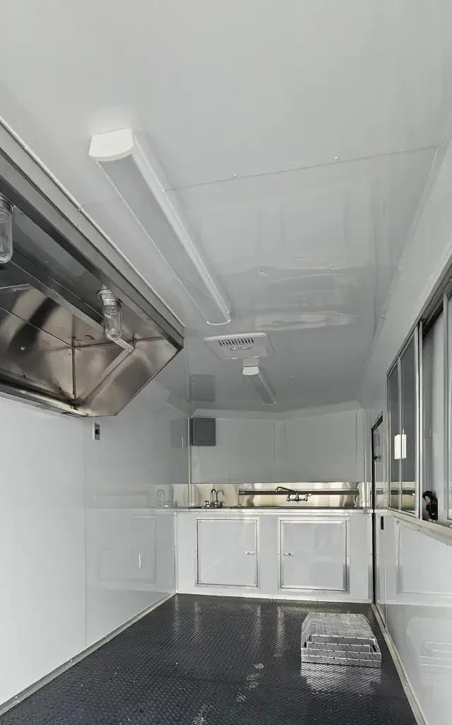 Interior of a BJP concession trailer showing a commercial hood, sink area, lighting, air conditioner and electrical panel